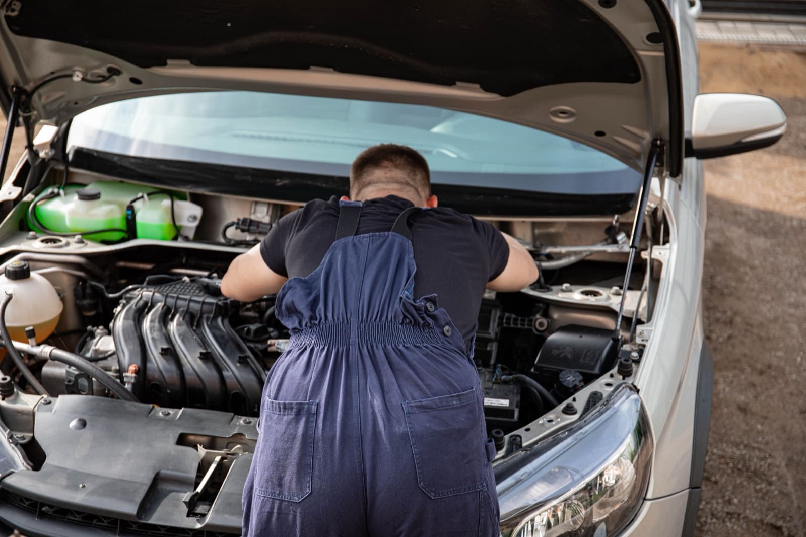 Stock photo of a mechanic working under a car hood